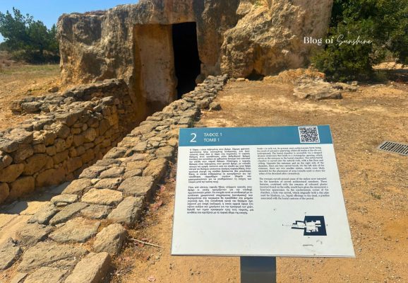 Information sign for Tomb 1 at Tombs of the Kings in Paphos Cyprus with the tomb entrance behind it