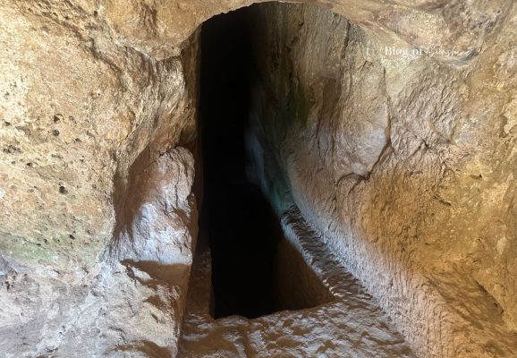 Dark rock-cut passage inside Tomb 3 at Tombs of the Kings in Paphos Cyprus